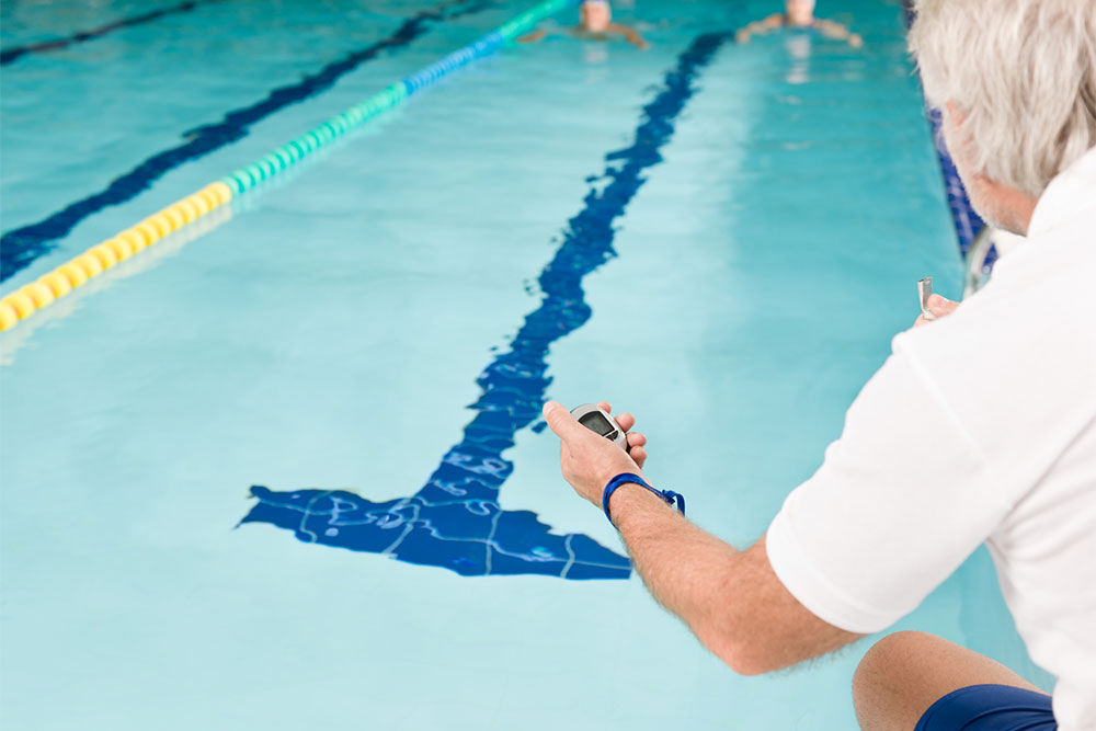 official holding stop watch by pool side