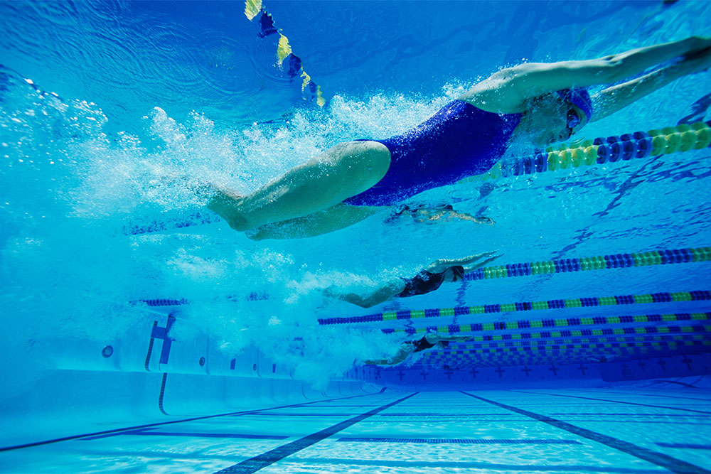 Female participants swimming underwater during a swimming race