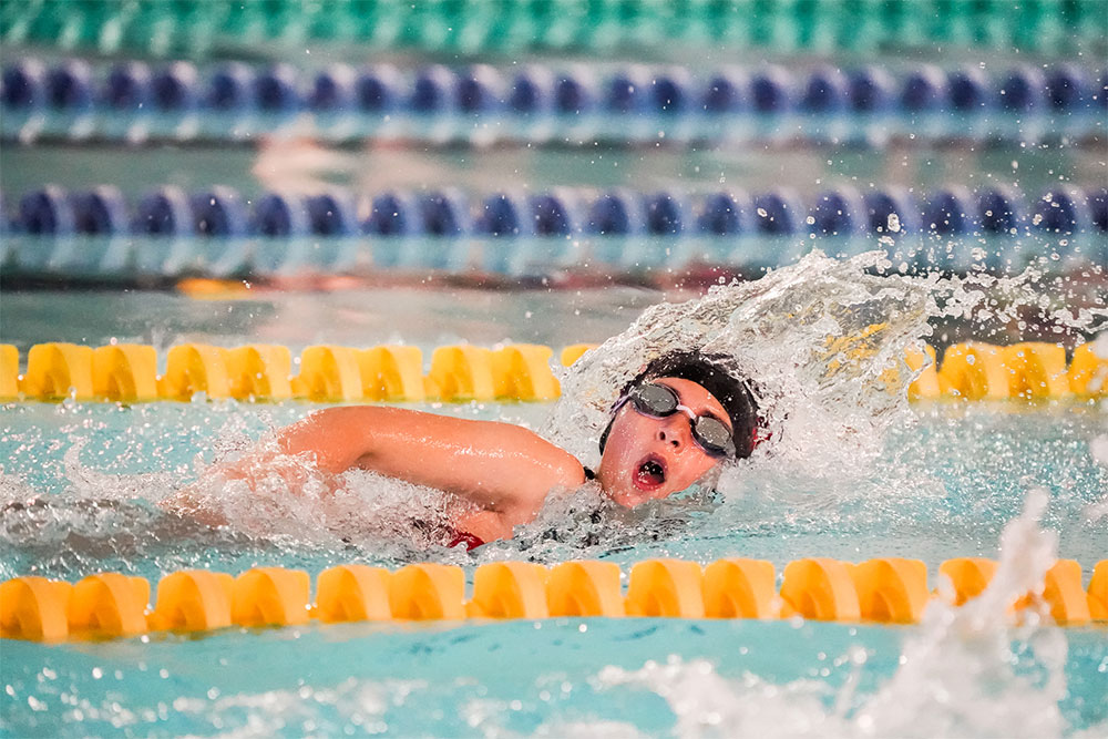 Young swimmer performing the front crawl stroke in a pool