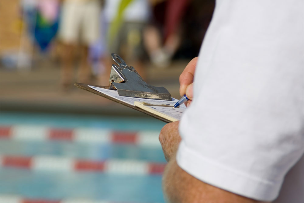 official holding clipboard facing pool