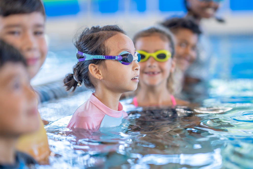 kids in swimming pool wearing goggles